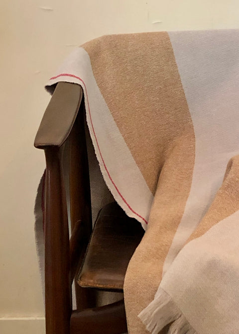 DETAIL OF DETAIL OF PONCO GUARDA, MADE IN TWO BEAUTIFUL COLORS; CLASSICAL BEIGE AND PALE BLUE. THE PONCHO IS MADE IN 50% BIO COTTON, 50% BIO WOOL. THE PONCHO HAS A RED LISTING, AND A BEAUTIFUL STAMP EMBROIDERED IN RED ON THE LEFT FRONT PANEL (FOR THE WEARER)