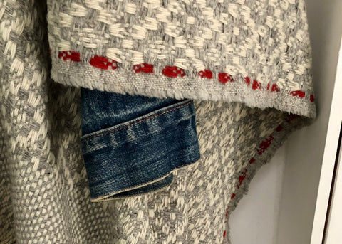 Detail from the etiquette with blanket Manteigas, SchoolofLifeProjects, made in 100% bio wool. Colors wool white, grey melange and bright red listing