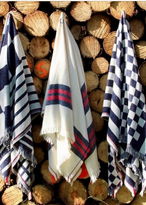 THREE BEAUTIFUL PONCHO'S HANGING ON A WALL OF WOODLOGS IN NATIONAL PARK SERRA DA ESTRELA. FROM THE RIGHT TO THE LEFT; PONCHO BIG KOMPEL, STRIPED PONCHO SAO LOURENCO AND PONCHO KOMPEL