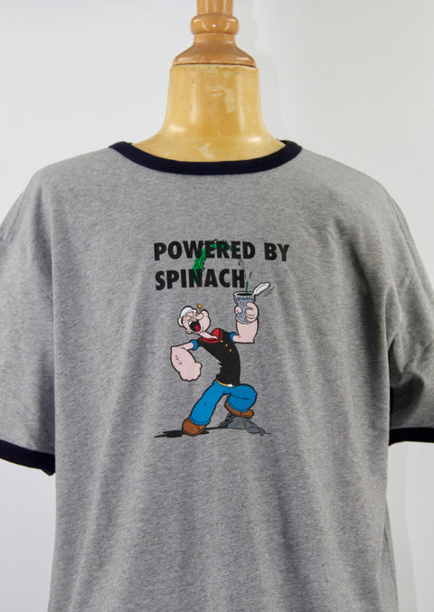 DETAIL OF SCHOOLOFLIFEPROJECTS RINGER TEE WITH POPEYE, THE TEXT SAYS, POWERED BY SPINACH 