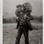 Picture of a 20th century shepherd with a sheep on his shoulders. Black/white