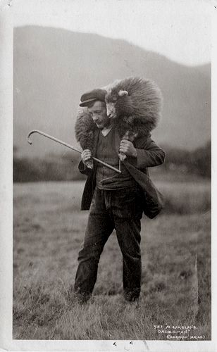 Picture of a 20th century shepherd with a sheep on his shoulders. Black/white